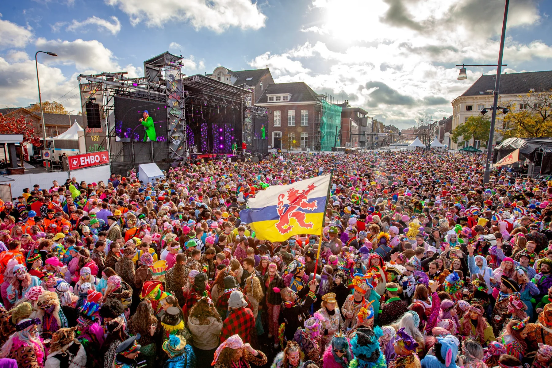 Volle Stationsplein in Roermond met feestend publiek voor het podium